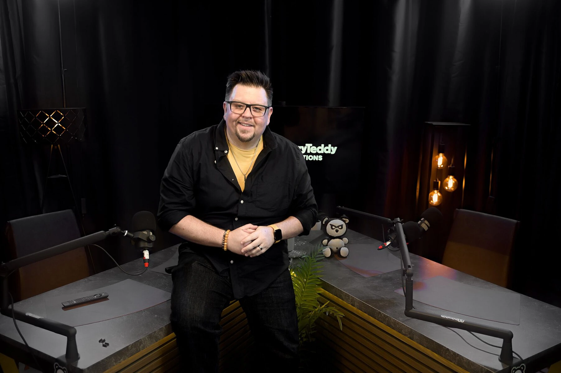 Kommunikationsstudio für Social Media & Podcast Mann im Aufnahmestudio mit Mikrofonen und Teddy, bereit für Social Media & Podcast-Aufnahmen.