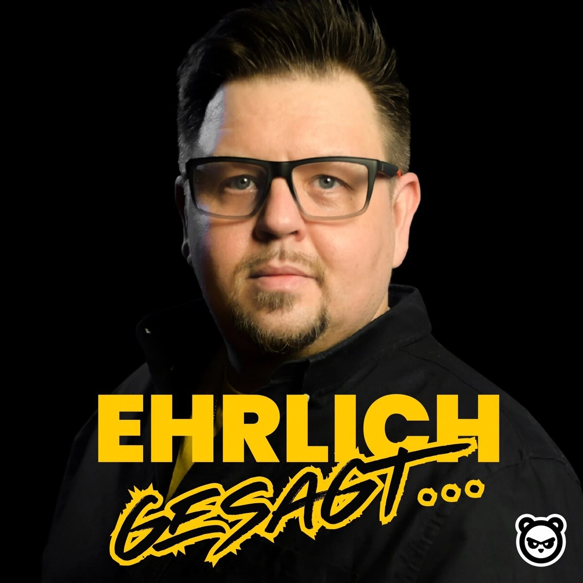Ehrlich gesagt... Porträt eines Mannes mit Brille, schwarzem Hemd, schwarzem Hintergrund.